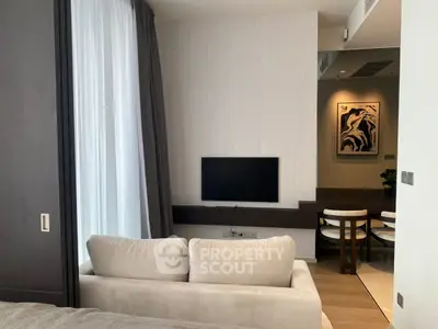 Modern living room with sleek design, featuring a wall-mounted TV and elegant decor.