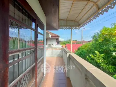 Charming balcony with decorative awning and scenic neighborhood view.