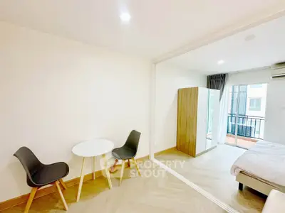 Modern studio apartment with cozy dining area and balcony view