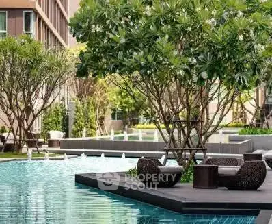 Luxurious outdoor pool area with stylish seating and lush greenery in a modern residential complex.