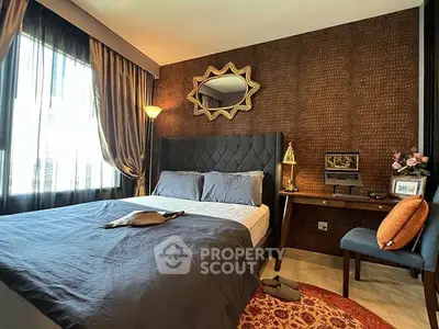 Luxurious bedroom with elegant decor and natural light, featuring a stylish mirror and cozy workspace.