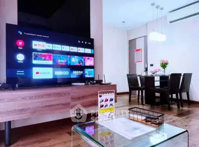 Modern living room with sleek TV setup and elegant dining area, perfect for entertainment and relaxation.