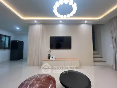 Modern living room with sleek design and stylish lighting, featuring a wall-mounted TV and contemporary furniture.