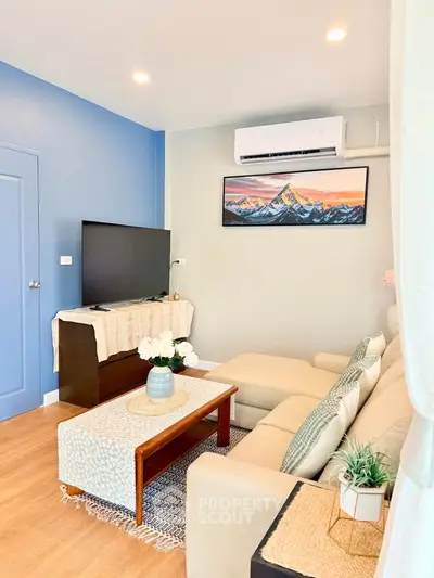 Charming living room with cozy seating, stylish decor, and modern air conditioning in a vibrant home.