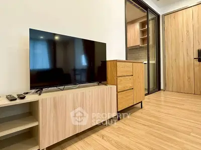 Modern living room with sleek TV stand and wooden flooring in a stylish apartment.