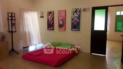 Cozy bedroom with minimalist decor and vibrant bedding, featuring unique wall art and natural light.