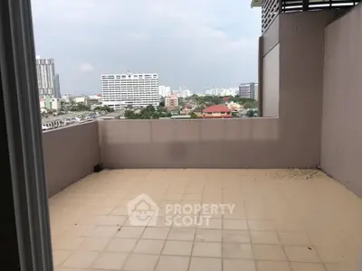 Spacious balcony with city view in modern apartment building.