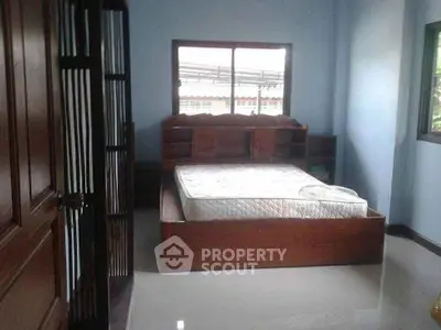 Spacious bedroom with large window and wooden bed frame