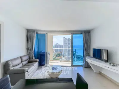 Modern living room with ocean view and sleek furnishings in a high-rise apartment.