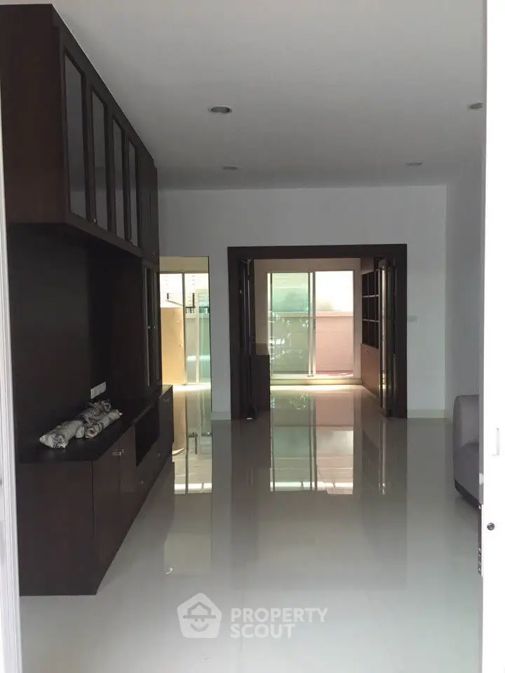 Spacious modern living room with glossy floors and ample natural light.