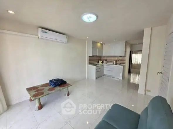 Spacious open-plan living room with modern kitchen and minimalist decor.