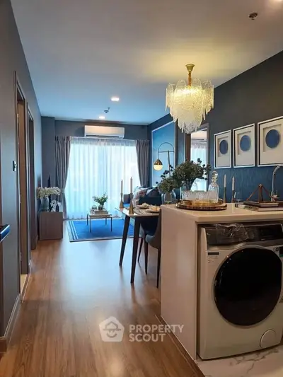Modern living room with elegant chandelier and open kitchen layout