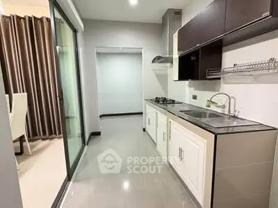 Modern kitchen with sleek cabinetry and gas stove in open layout apartment.
