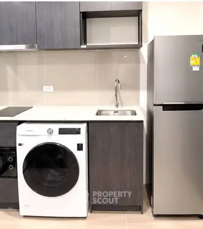 Modern kitchen with sleek appliances including washing machine and fridge, perfect for urban living.