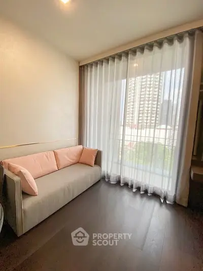 Modern living room with elegant sofa and floor-to-ceiling window offering city view.