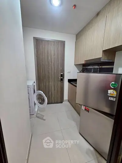 Modern kitchen with washing machine and fridge in compact layout