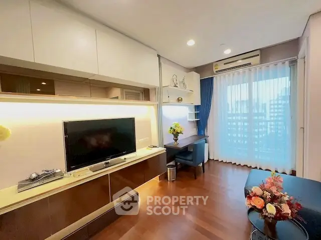 Modern living room with wooden flooring, TV unit, and large window with city view.