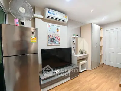 Modern living room with sleek furniture and appliances, featuring a flat-screen TV and stylish decor.