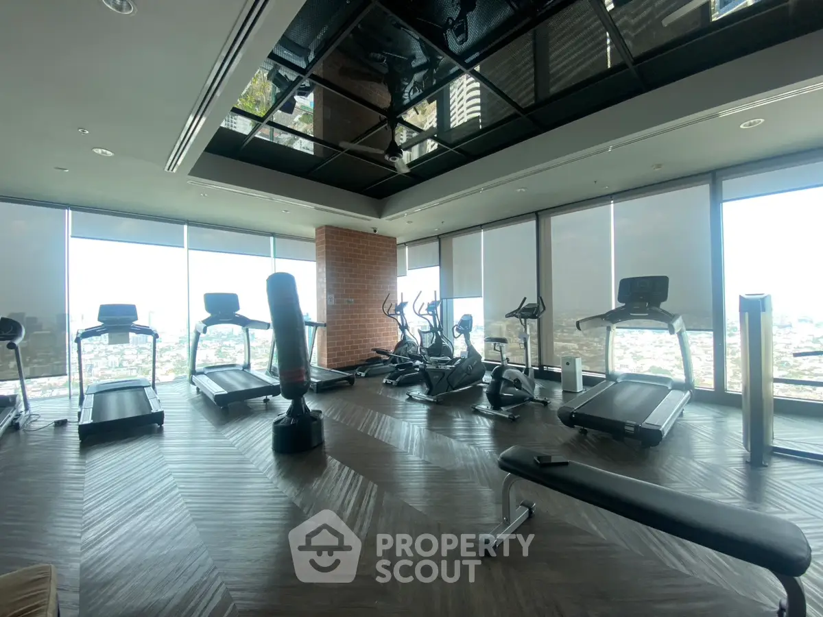 Luxurious high-rise gym with panoramic city views and modern fitness equipment.