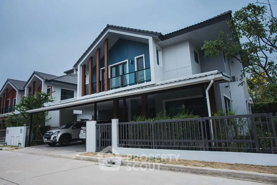 Modern two-story house with sleek design and spacious driveway in a suburban neighborhood.