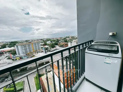 High-rise balcony with washing machine and cityscape view, perfect for urban living.