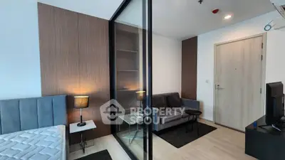 Modern apartment interior with glass partition, cozy living area, and stylish decor.