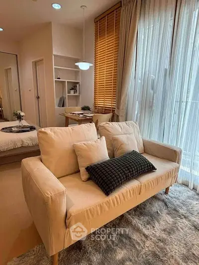Cozy living room with plush sofa and natural light in modern apartment