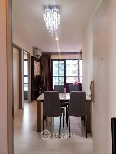 Modern dining area with elegant chandelier and large windows in a stylish apartment.