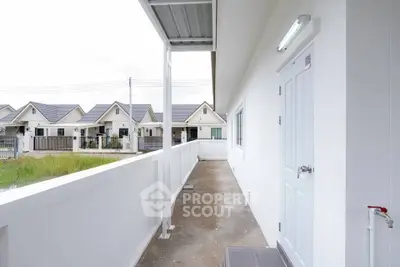 Modern townhouse exterior with white facade and spacious balcony