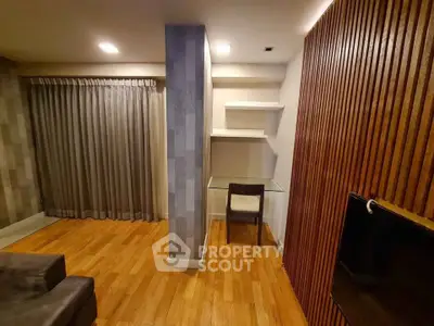 Modern living room with wooden flooring and stylish wall paneling, featuring a cozy study nook.