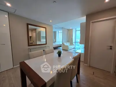 Spacious modern living and dining area with elegant furnishings and large windows offering natural light.