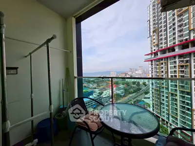 Stunning balcony view with modern high-rise buildings and ocean in the background.