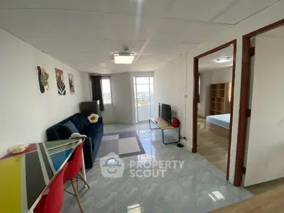 Modern living room with stylish decor and natural light, featuring a cozy sofa and dining area.