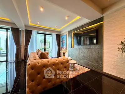 Luxurious living room with elegant sofa and modern decor, featuring large windows and stylish lighting.