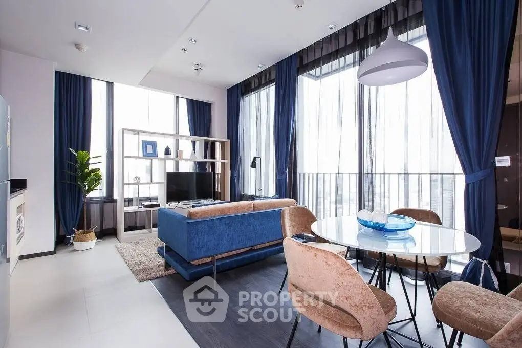 Modern living room with stylish furniture and large windows offering natural light.