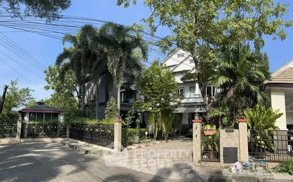 Charming suburban home with lush greenery and spacious driveway in a serene neighborhood.