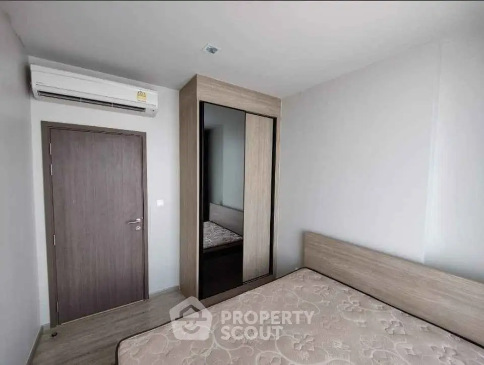Modern minimalist bedroom with air conditioning and wooden wardrobe, perfect for comfort and style.
