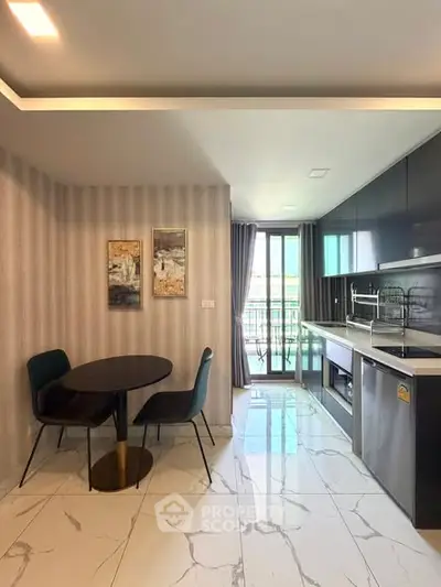 Modern kitchen with sleek cabinets and dining area, featuring marble flooring and natural light.