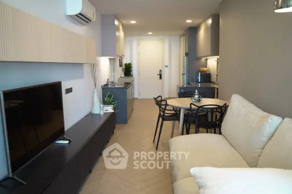 Modern living room with sleek furniture and open kitchen layout in a stylish apartment.