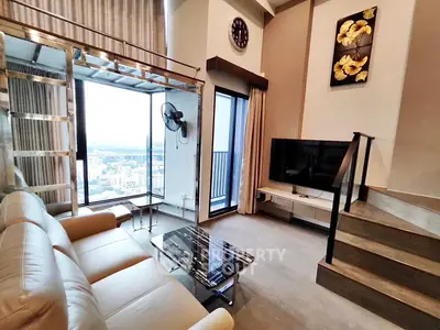 Modern living room with city view, featuring stylish decor and a cozy seating area.