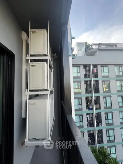 Modern balcony with air conditioning units and urban building view