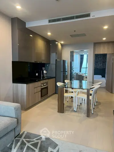 Modern open-layout kitchen with sleek cabinetry and dining area in stylish apartment.