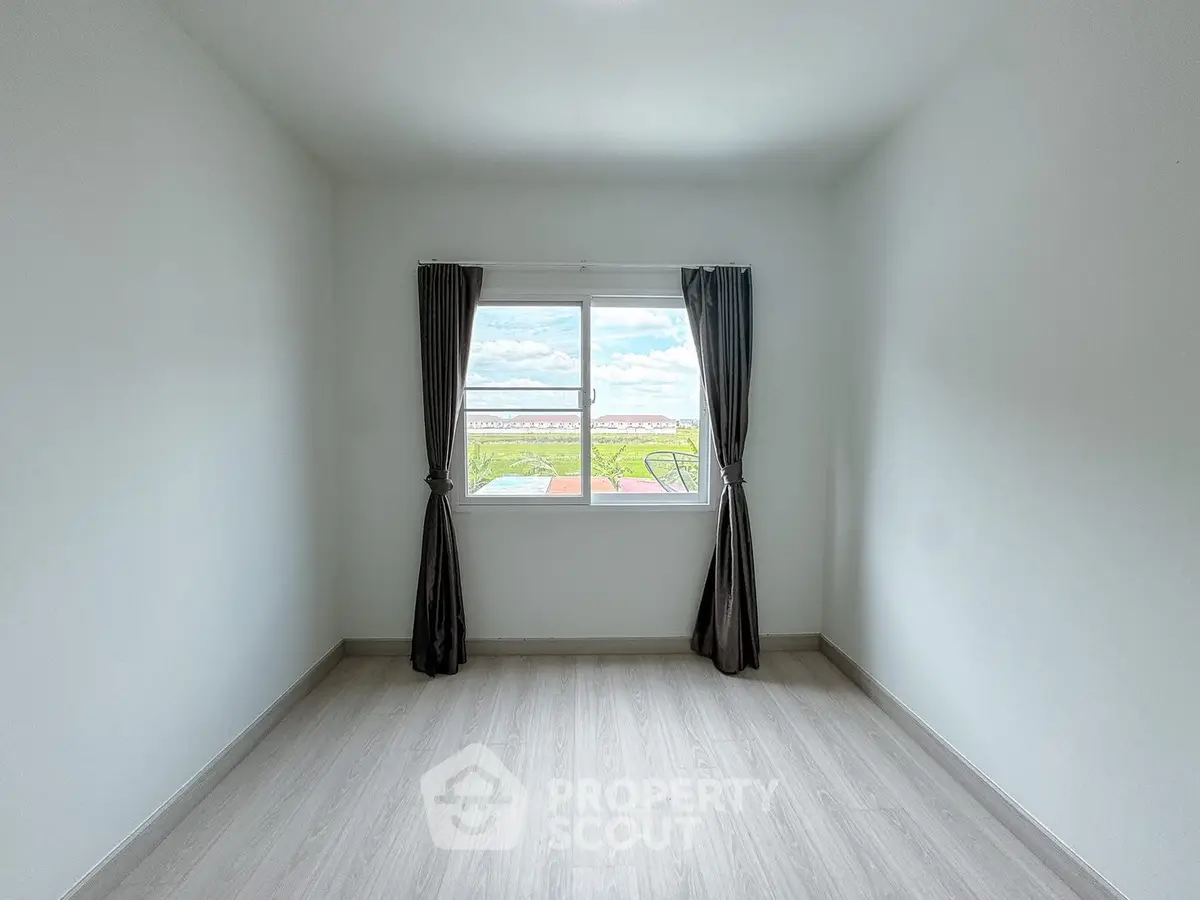 Bright empty room with large window and scenic view, ideal for customization.