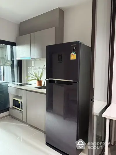 Modern kitchen with sleek black refrigerator and stylish cabinetry