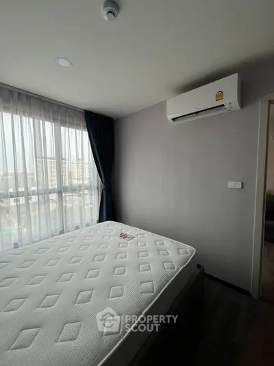 Modern bedroom with large window and air conditioning in a stylish apartment.