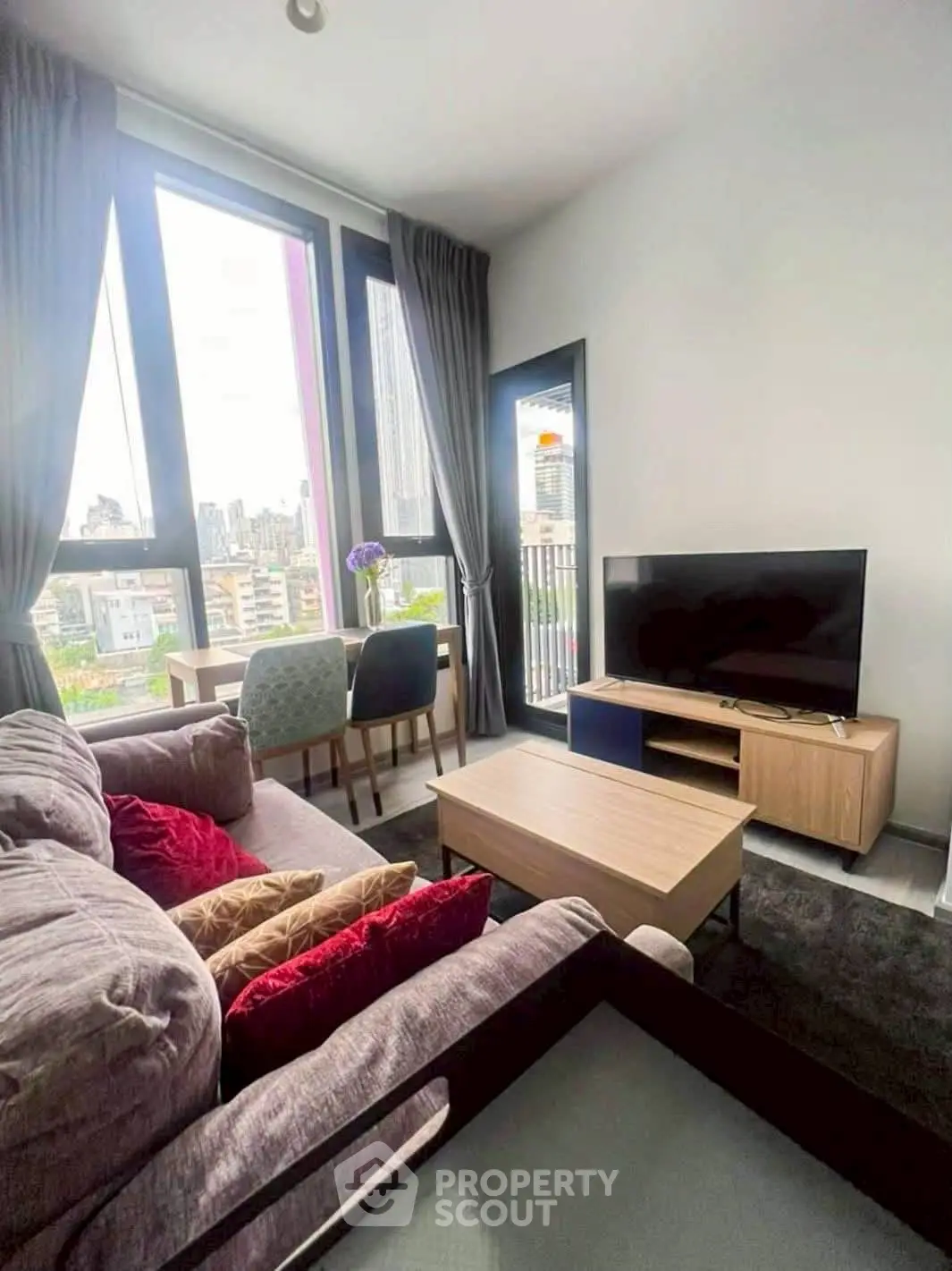 Modern living room with city view, cozy sofa, and dining area, perfect for urban living.