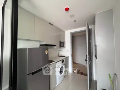 Modern compact kitchen with appliances including fridge, washing machine, and microwave.