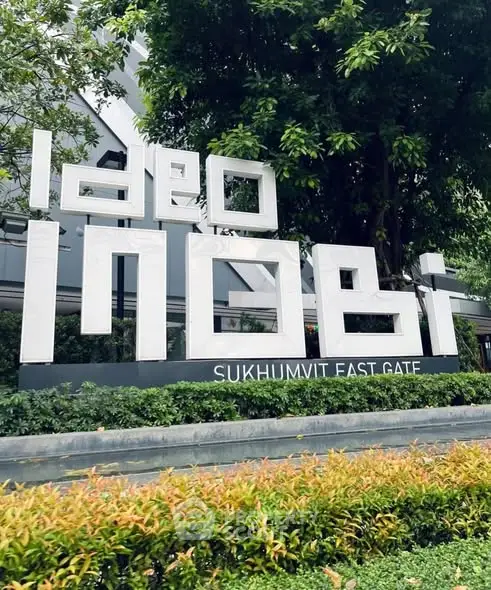 Modern condominium entrance with lush greenery at Ideo Sukhumvit East Gate.