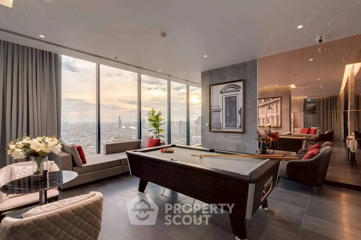 Luxurious living room with pool table and stunning city view in high-rise apartment.