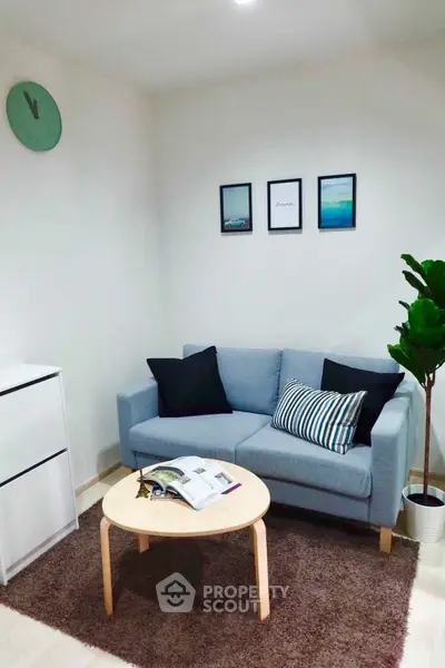 Cozy living room with modern decor, featuring a blue sofa, stylish coffee table, and wall art.